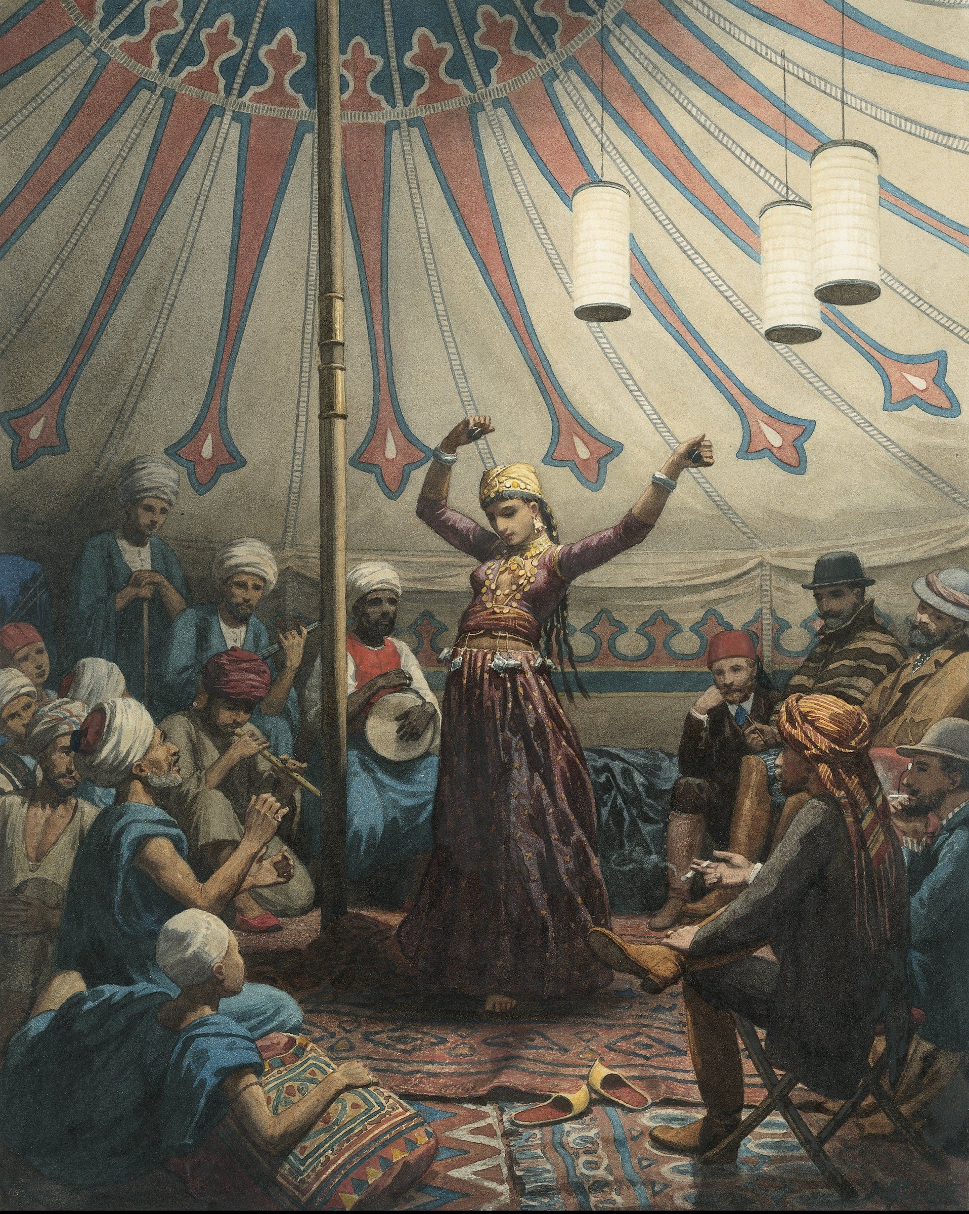 Woman in ornate burgundy costume and jeweled headdress dances with raised arms inside an elaborately striped tent, surrounded by musicians and spectators