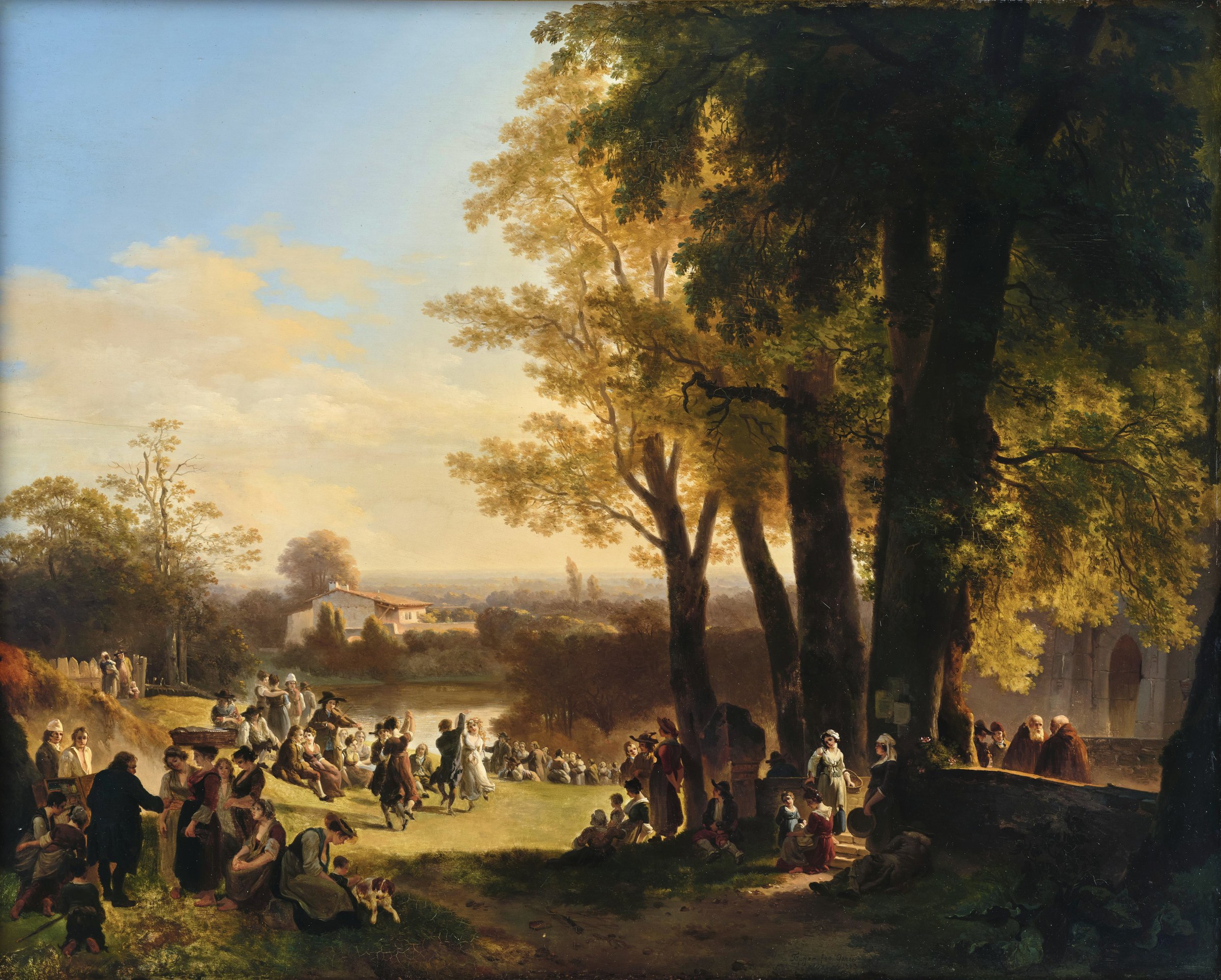 Hundreds of people gather in a grassy clearing beside a river in an alpine landscape for a village celebration, with trees, distant chapel, and musicians