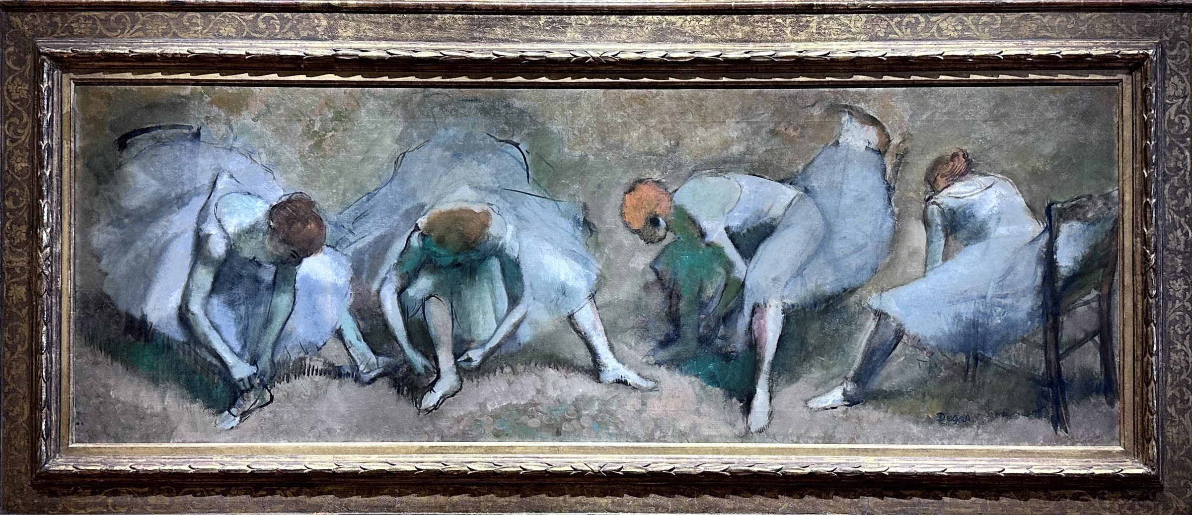 Five female ballet dancers in pale tutus bend and stretch in informal poses across a neutral background.