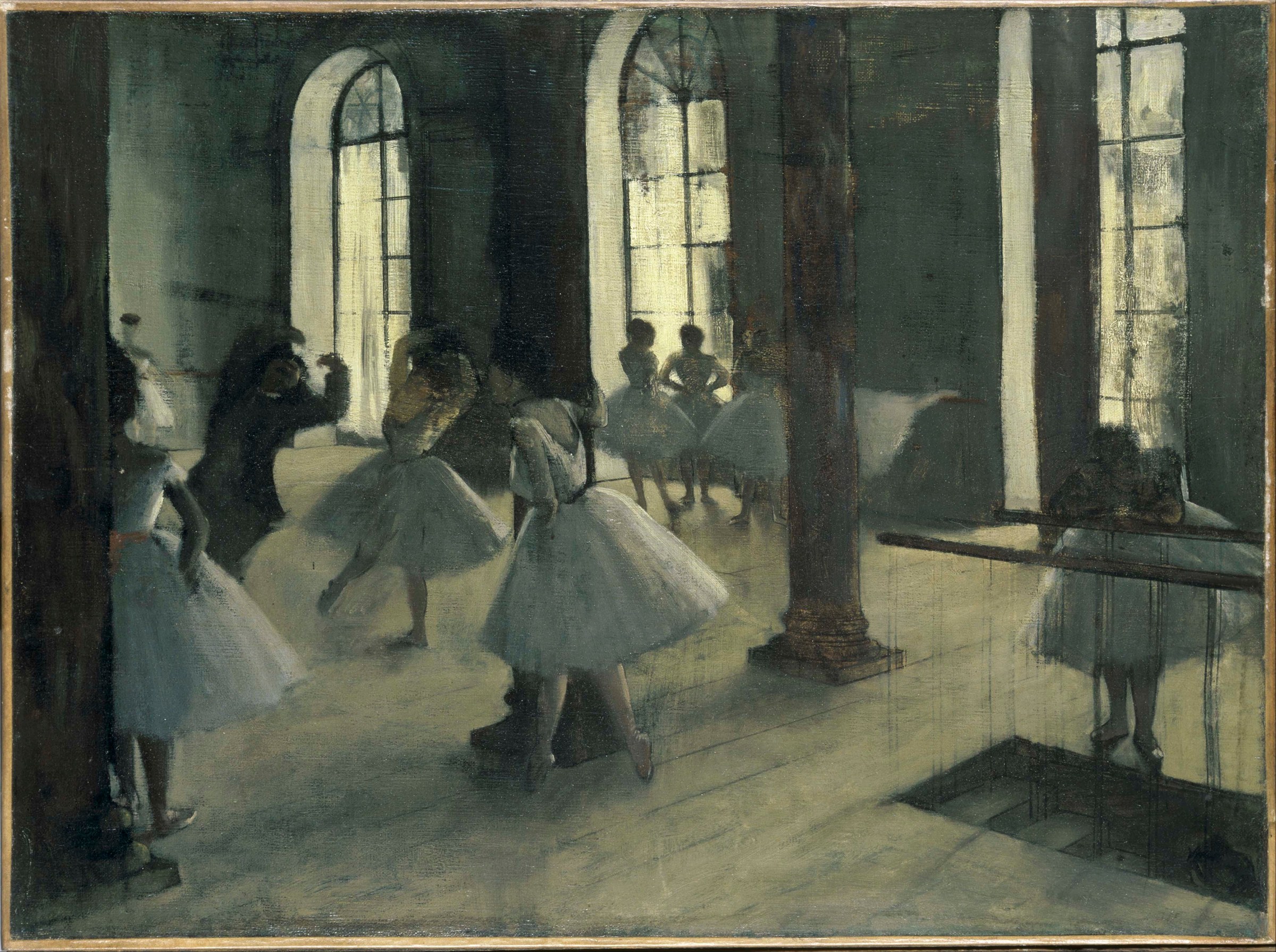 Young female ballet dancers in white tutus rest and converse in a sunlit studio with arched windows and classical columns.