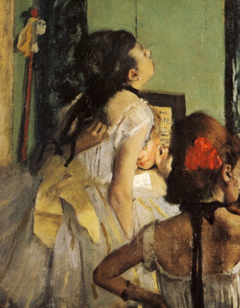 Three young dancers in a studio: two standing in pale shifts, one seated in a red-banded hat, facing a bare wall with warm ochre and cool green tones.