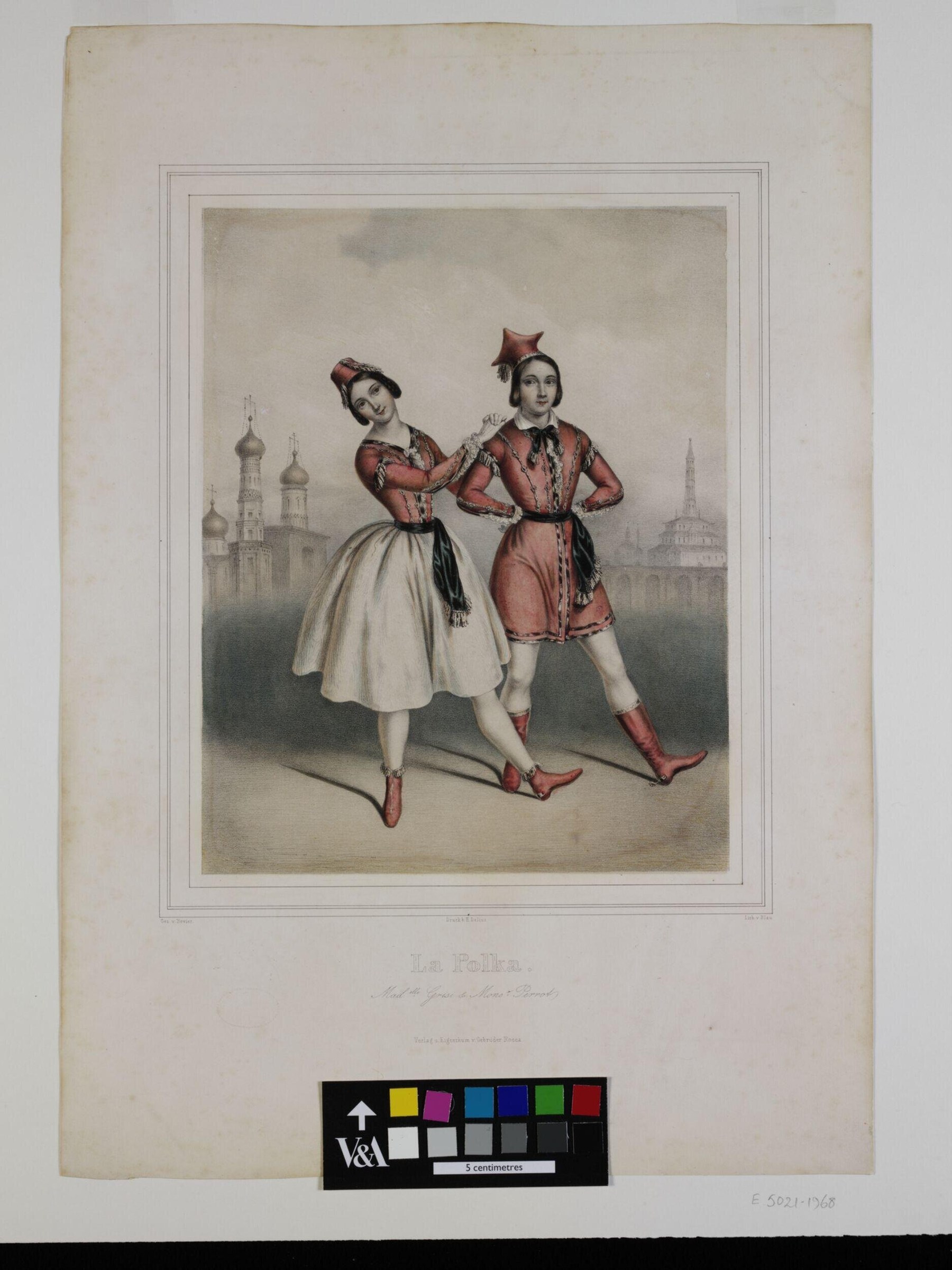 Two dancers in Russian costume perform the polka on a stage before onion-domed churches. The left dancer bounces with raised knees; the right stands with hand