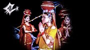 Three women in vibrant traditional dress pose against black background in celebratory positions, representing Jhijhiya, a Mithila folk dance.