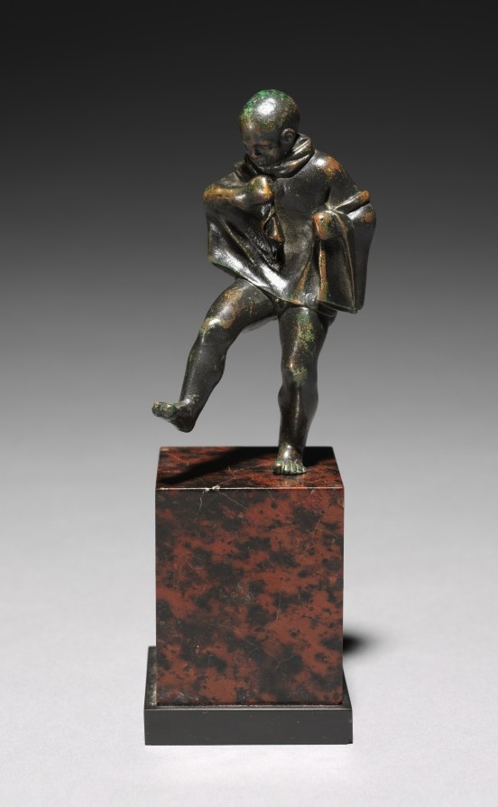 Bronze sculpture of a nude adolescent boy in dynamic twisted pose with raised leg and arms crossed, on marble plinth.