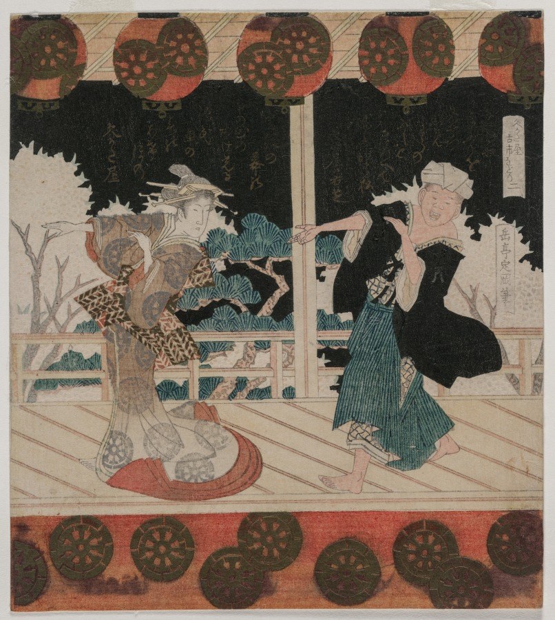 Two costumed performers on a wooden stage: one in an elaborate patterned robe with tall headdress, one in blue striped robe, both in animated gesture toward