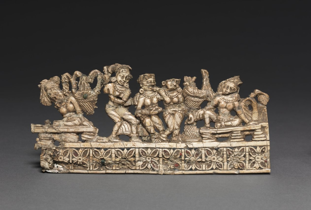 Gilt bronze relief showing seven putti in varied poses amid mythological creatures and decorative palmette border.