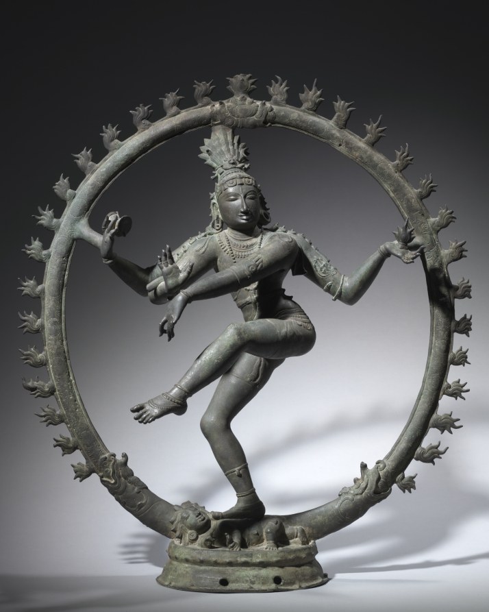 Bronze sculpture of Nataraja (Shiva) dancing within an oval flame-motif frame, with raised leg, extended arms, crown, and jewelry.