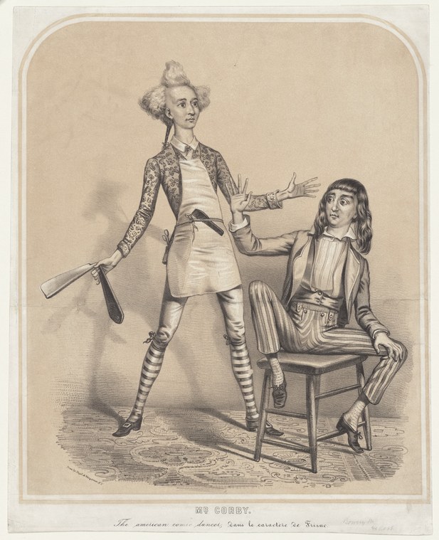 A standing male dancer in striped stockings and patterned jacket executes a wide-legged stance with arms spread, watched by a seated younger man on a wooden