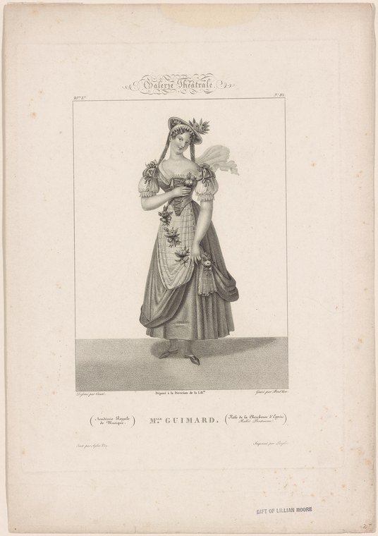 A woman in an ornate 18th-century stage costume with high waist and draped skirt stands frontal, wearing a laurel wreath and holding a feathered fan.