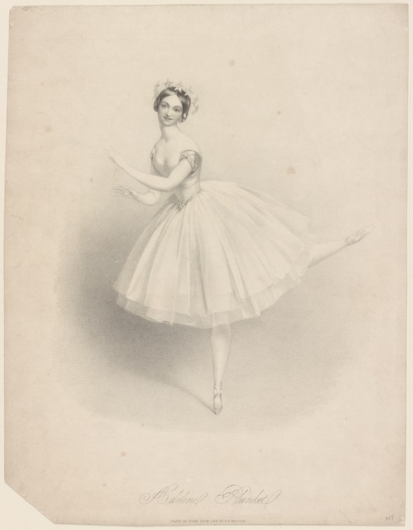 A woman in a white tulle tutu, seen from the side, balanced on pointe with one leg extended behind her, arms open, wearing a decorative headpiece.