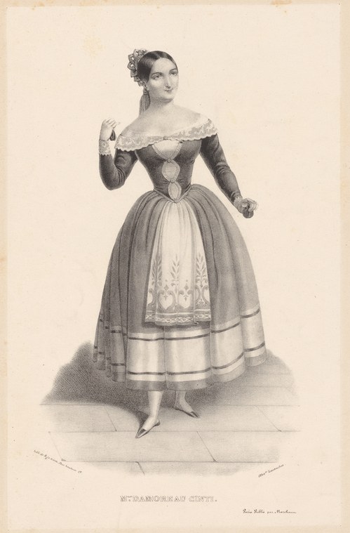 Woman in 1840s Romantic ballet costume with off-shoulder dark bodice and embroidered full skirt, standing in a composed theatrical pose.