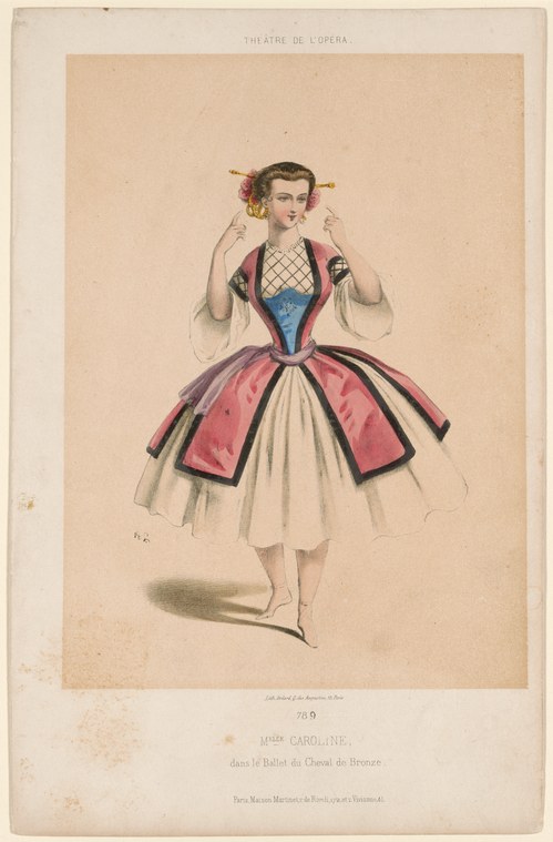 A woman in a blue embroidered corset and full pink skirt with flowers in her hair stands with arms raised and bent elbows, in a pose of joyful movement.