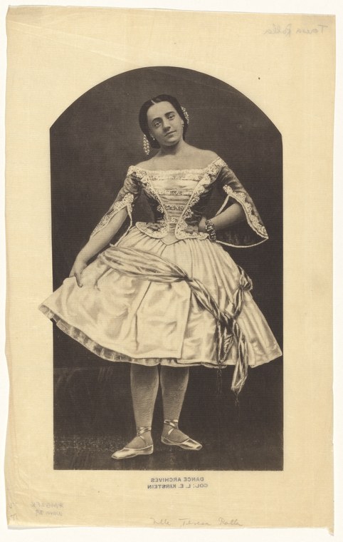 Studio photograph of a young woman in white Romantic-era ballet costume with fitted bodice, full skirt, and pointe shoes, posed against a dark background.