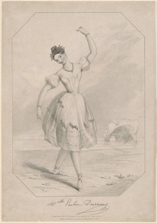 A young woman in a pale muslin dress with floral embroidery stands in an elevated ballet pose, one arm raised, on a bare stage.