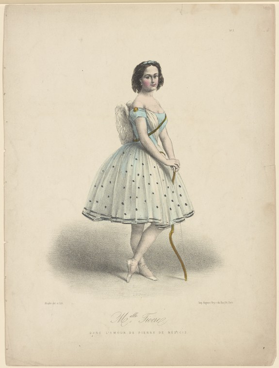 A young woman in a white tulle ballet skirt and blue corset stands in classical ballet pose, holding a thin cane.
