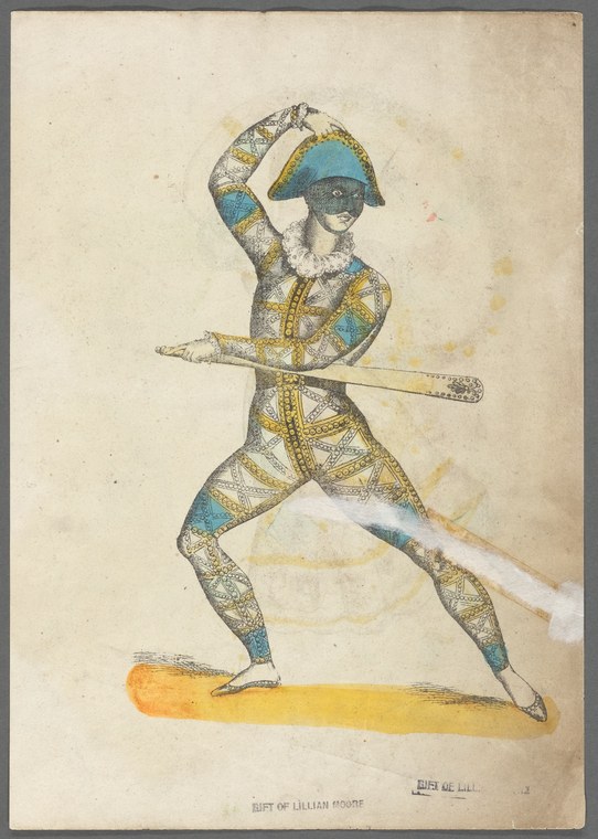 A man in a blue helmet and ornate patterned tunic stands in a wide lunge on a yellow stage floor, holding a staff, with his raised arm near his head.