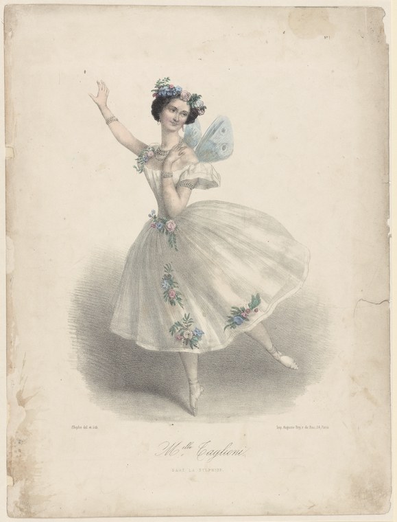 A young woman in a white tulle tutu stands en pointe in a high arabesque, one arm raised, crowned with flowers.