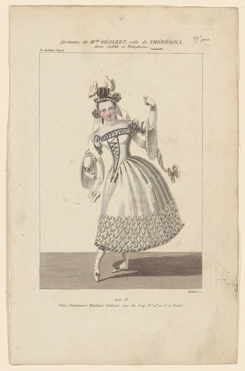 Woman in elaborate 1820s theatre costume with feathered headdress and patterned skirt, posed in ballet slippers with raised arms.