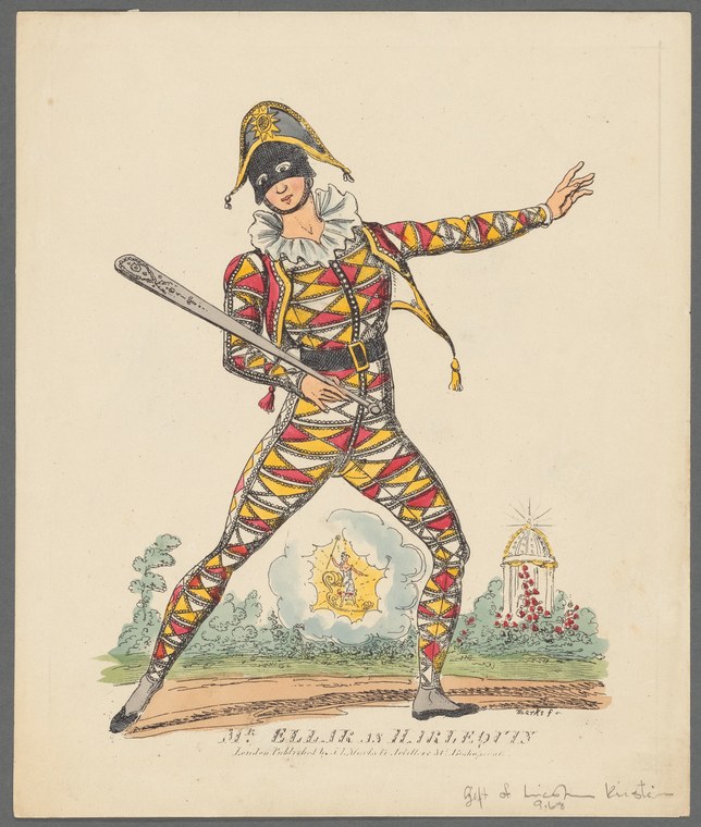 A theatrical performer in a diamond-patterned red, yellow and black Harlequin costume lunges forward with one arm extended, holding a wooden prop, against a
