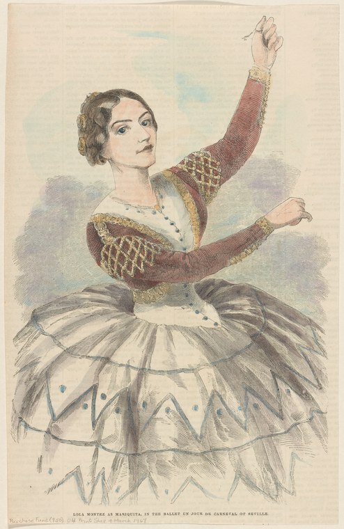 A female dancer in burgundy silk and white tulle skirt stands with left arm raised, right arm extended, in a classical ballet pose.