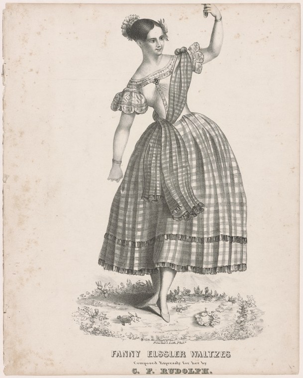A woman in a checkered plaid ball gown stands en demi-pointe with arms extended, in a classical ballet pose.