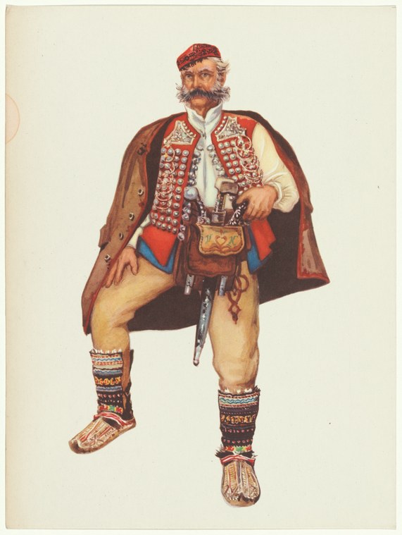 Bearded man in embroidered Balkan costume with red cap and cape, standing in formal pose.
