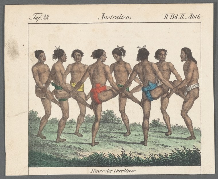 Eight nude or near-nude men in a circle, hands linked, wearing colorful loincloths and tall headdresses, on grass.