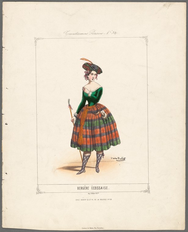 A woman in a green bodice and orange-and-green striped skirt holds a staff, wearing a plumed hat, standing still in theatrical costume.