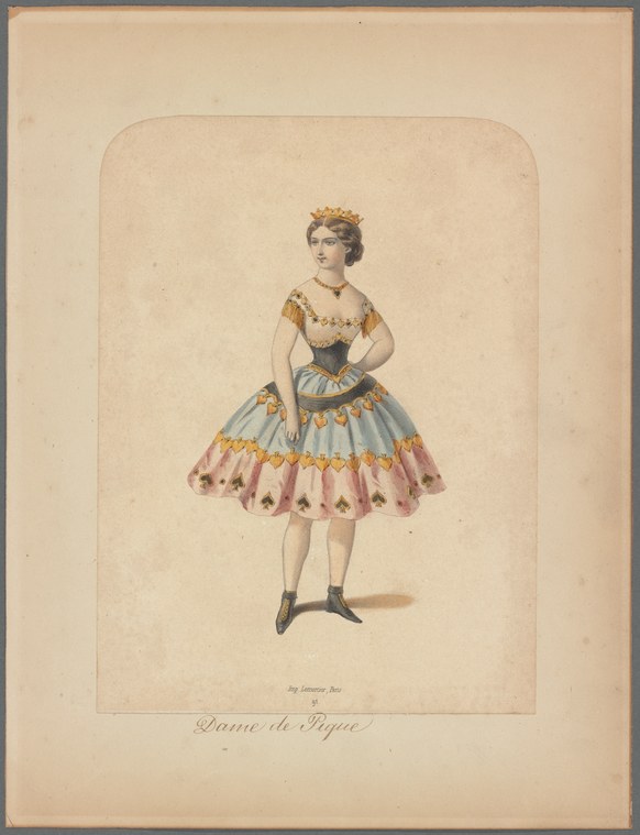 A woman in a mid-19th-century ballet costume with a short blue skirt, gold-trimmed bodice, tiara, and black boots, standing in a relaxed pose facing slightly