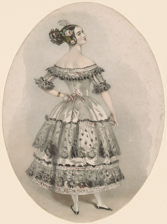 A woman in a tiered white silk dress with fringed trim stands in profile, head crowned with jewels, against a neutral background.