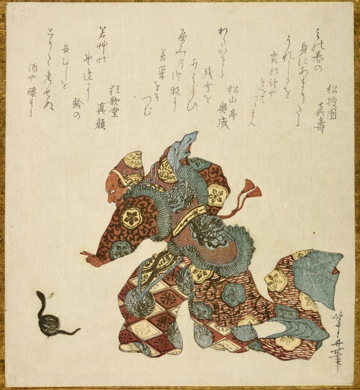 Elaborately costumed figure in layered red, gold, and teal garments with geometric ornaments, posed frontally in formal stillness against a cream background.