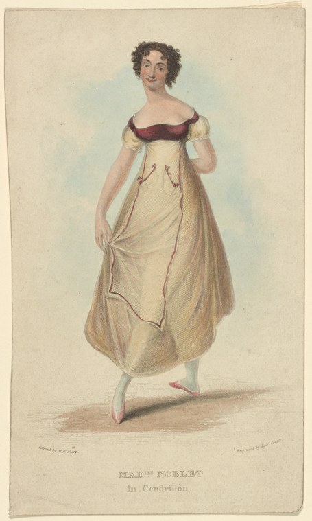 A young woman in a cream neoclassical gown with burgundy bodice ribbon and pink ballet slippers stands in balletic pose against a pale background.