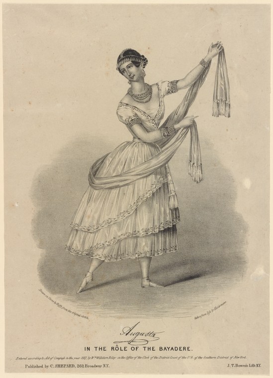 Woman in Romantic-era ballet costume holding drapery in a graceful standing pose, tiara and jeweled collar.