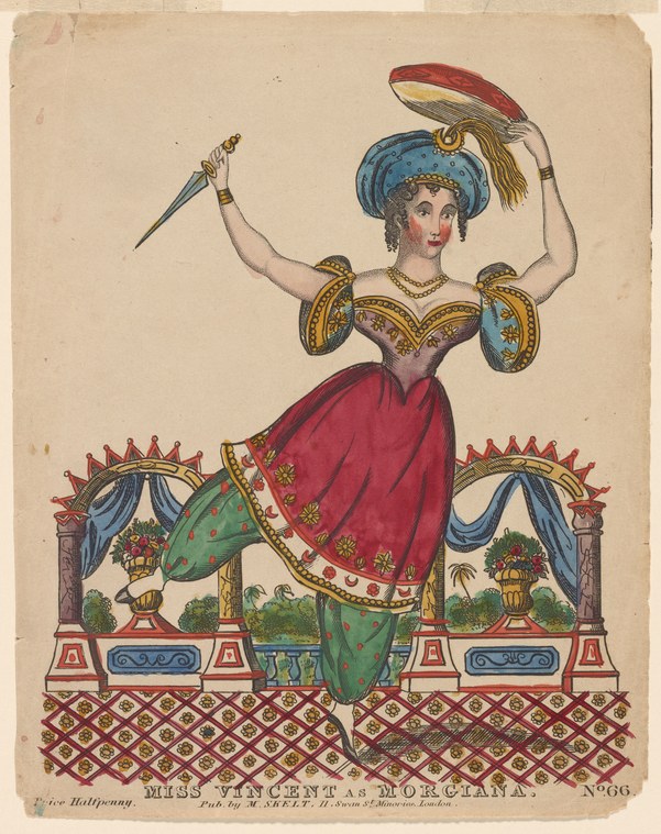 A woman in jeweled armor, turban, and harem pants stands in an armed pose on an ornate stage set, holding a curved dagger and shield.