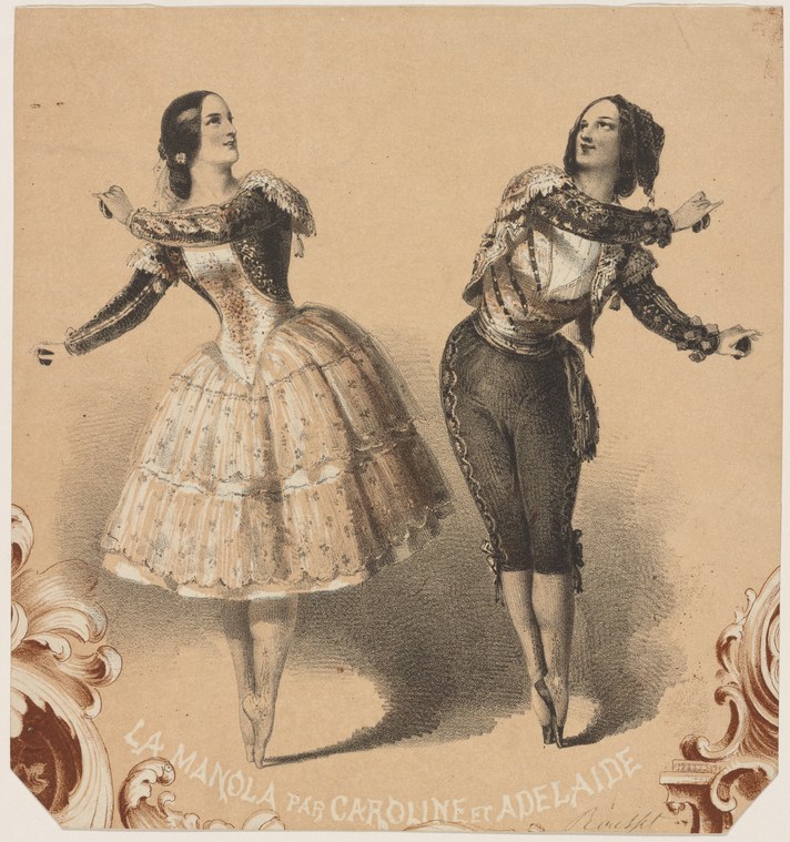 Two women in Spanish theatrical costume with decorative capes and full skirts, arms raised in expressive gesture, facing the viewer.