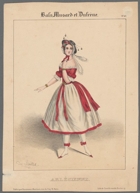 A young woman in a white skirt with red trim and feathered headdress, standing with one leg extended in a ballet pose.