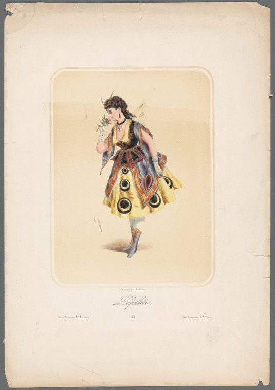 A woman in a yellow skirt with red and gold circular ornaments holds a floral crown, posed in a dark corseted bodice against a plain background.
