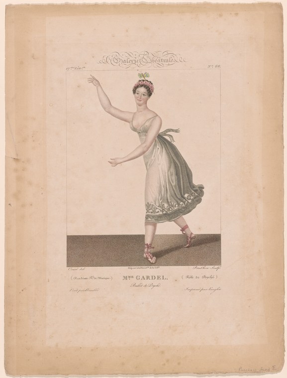 A woman in pale muslin gown with green drapery stands in a classical ballet pose, arms raised, wearing a small crown and heeled slippers.