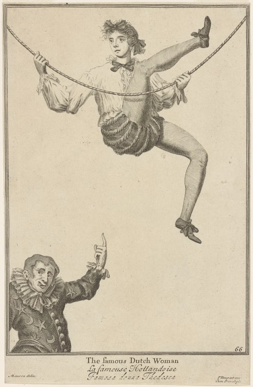 A woman suspended on two ropes in an acrobatic pose, legs splayed and arms extended, with a costumed man below gazing upward.