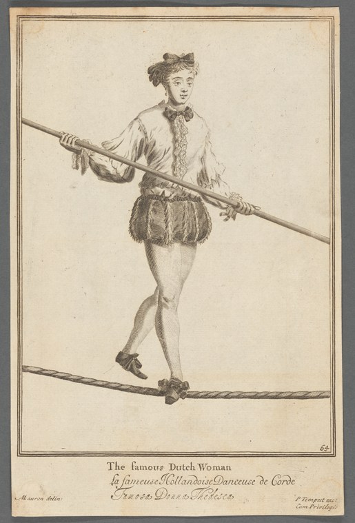 Female performer balanced on a slack rope, holding a long pole for balance, wearing a fringed skirt and fitted jacket.