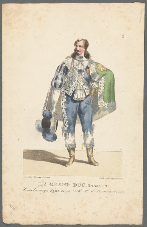 Man in blue silk coat with white lace, green cape, and extended pointed left foot, posed formally against cream background.