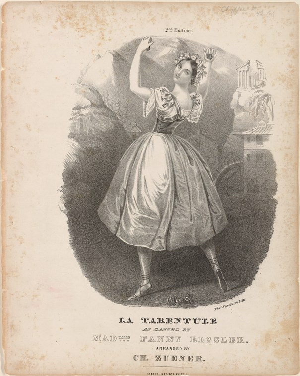 A woman in a white ballet skirt and flowered headdress twists and turns, one arm raised, her skirt flaring mid-spin against a dark background.