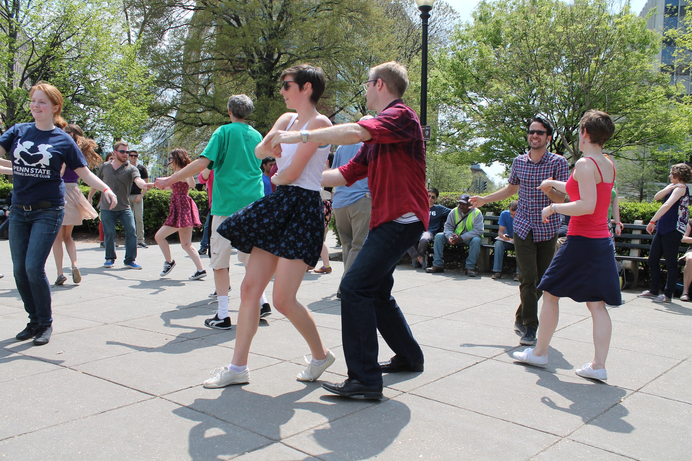 Multiple couples dancing Lindy Hop outdoors on a plaza at DuPont Circle, Washington DC, on a sunny afternoon in April 2014.