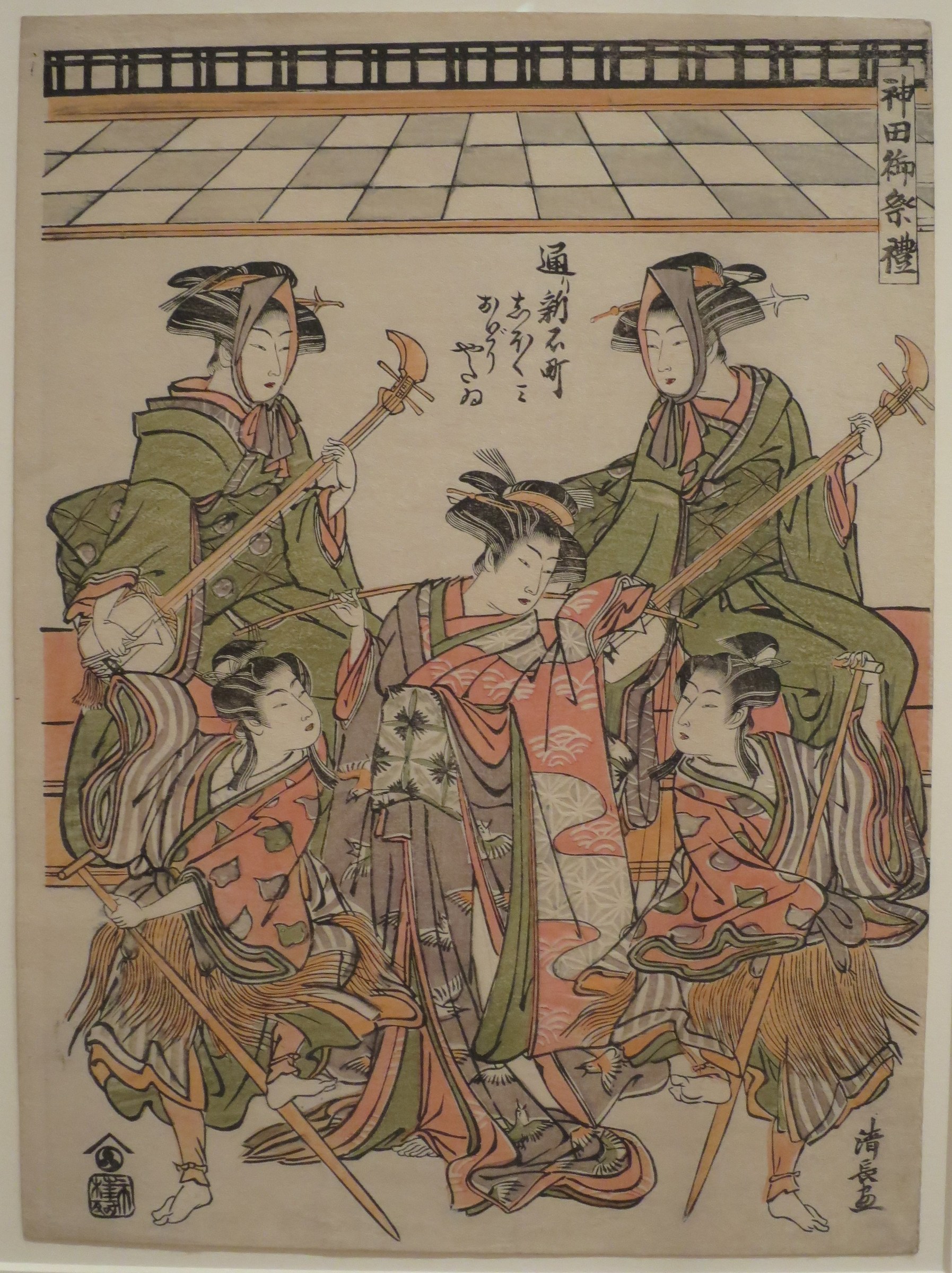 Six elaborately dressed women on a raised theatrical platform with geometric floor; central figure in coral robe surrounded by attendants in green.
