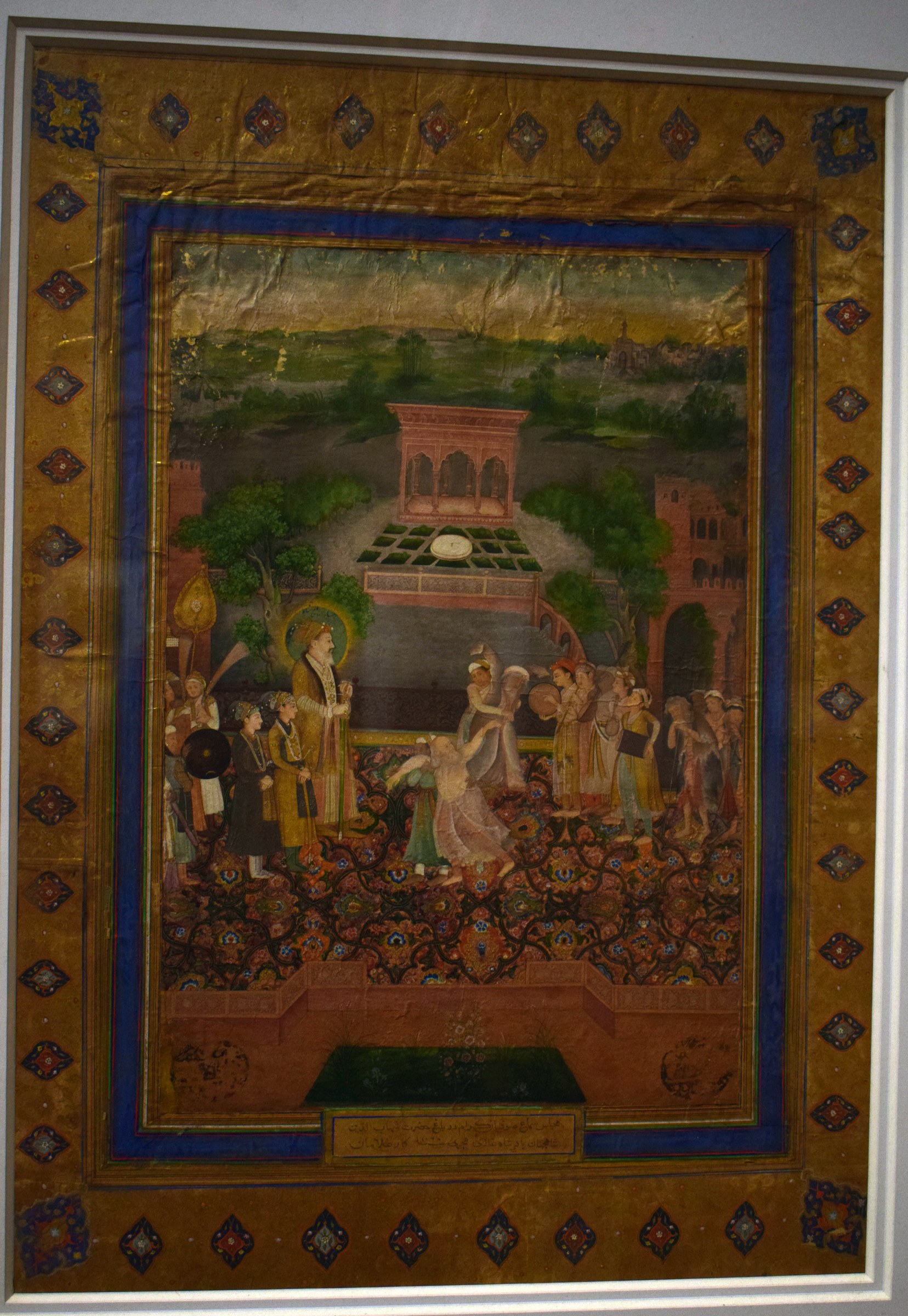 Mughal court scene with Emperor Shah Jahan (haloed) watching Sufi dancers in a palace pavilion, rendered in gold leaf and gouache.
