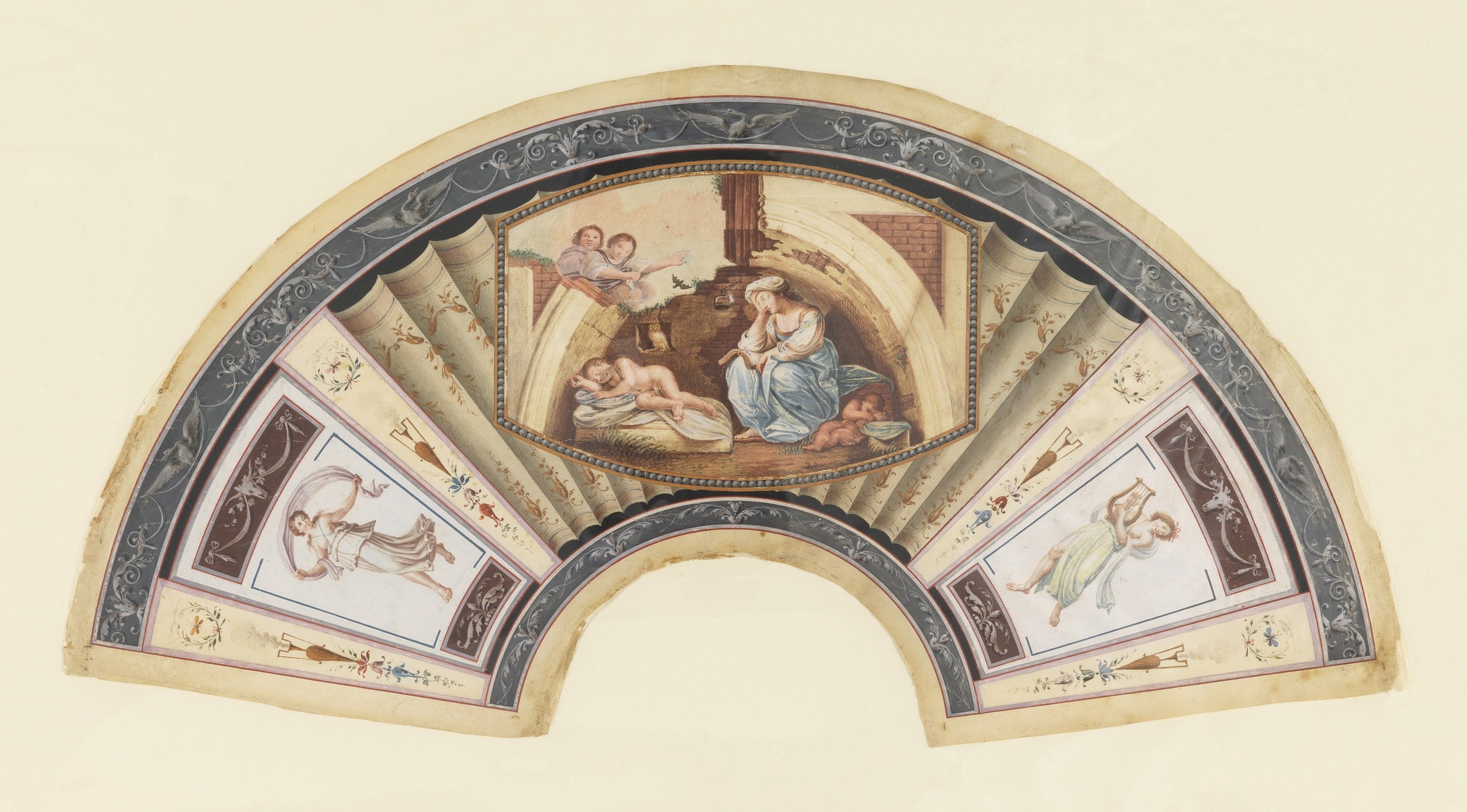 Semicircular fan leaf with classical dancers flanking a central scene of a woman tending sleeping children, painted in neoclassical style on parchment.