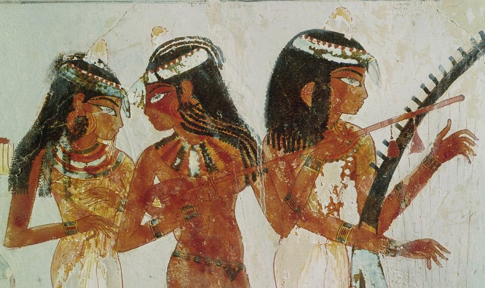 Three Egyptian women in elaborate dress: left plays double-pipe, center plays harp, right holds sistrum with raised arm and extended hand.