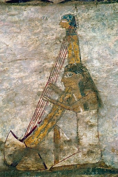 Egyptian tomb painting showing a woman in profile playing an arched harp, wearing a long linen garment and cap.