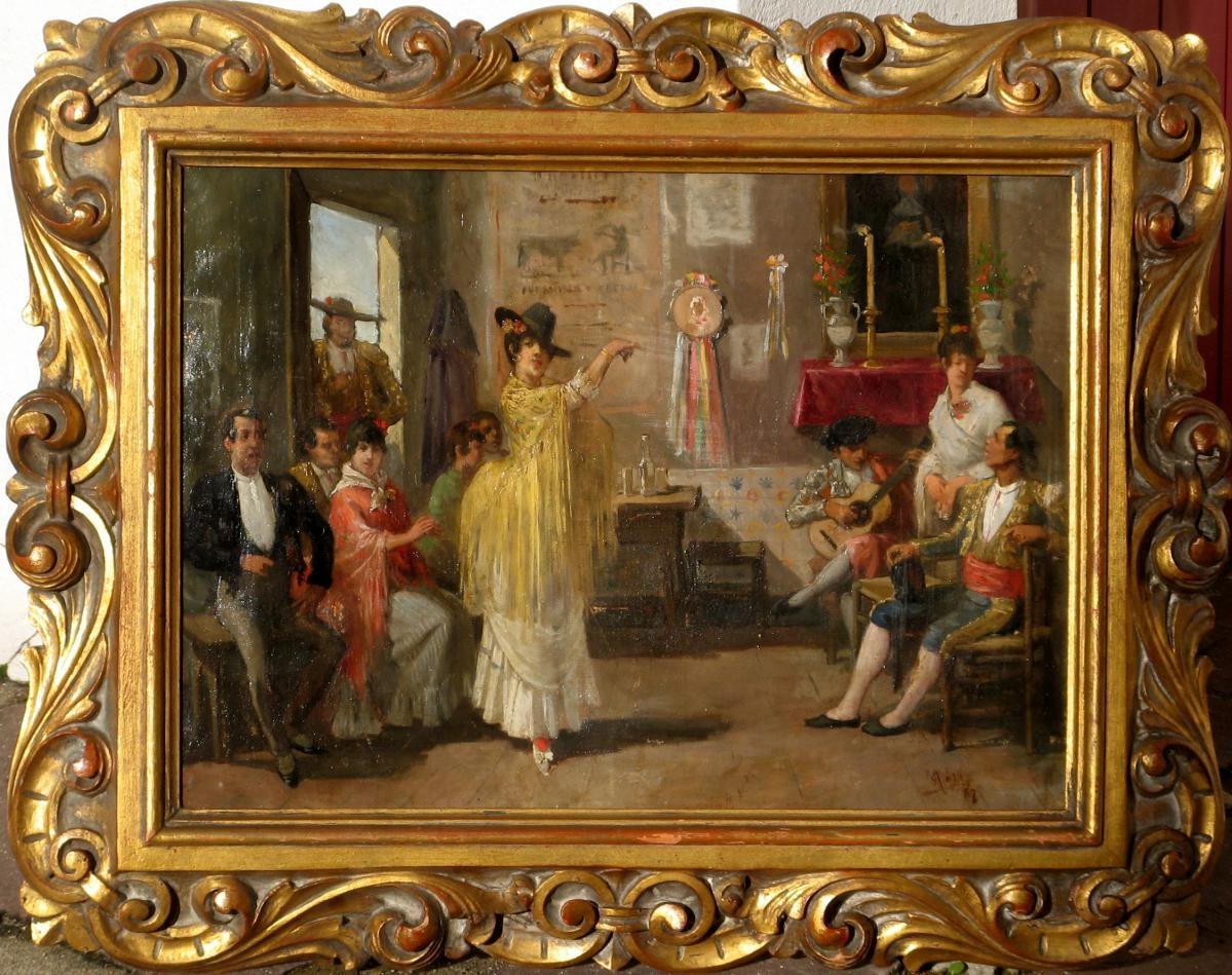 A woman in a yellow dress performs flamenco for assembled spectators in an ornate 19th-century salon, one arm raised in expressive gesture.