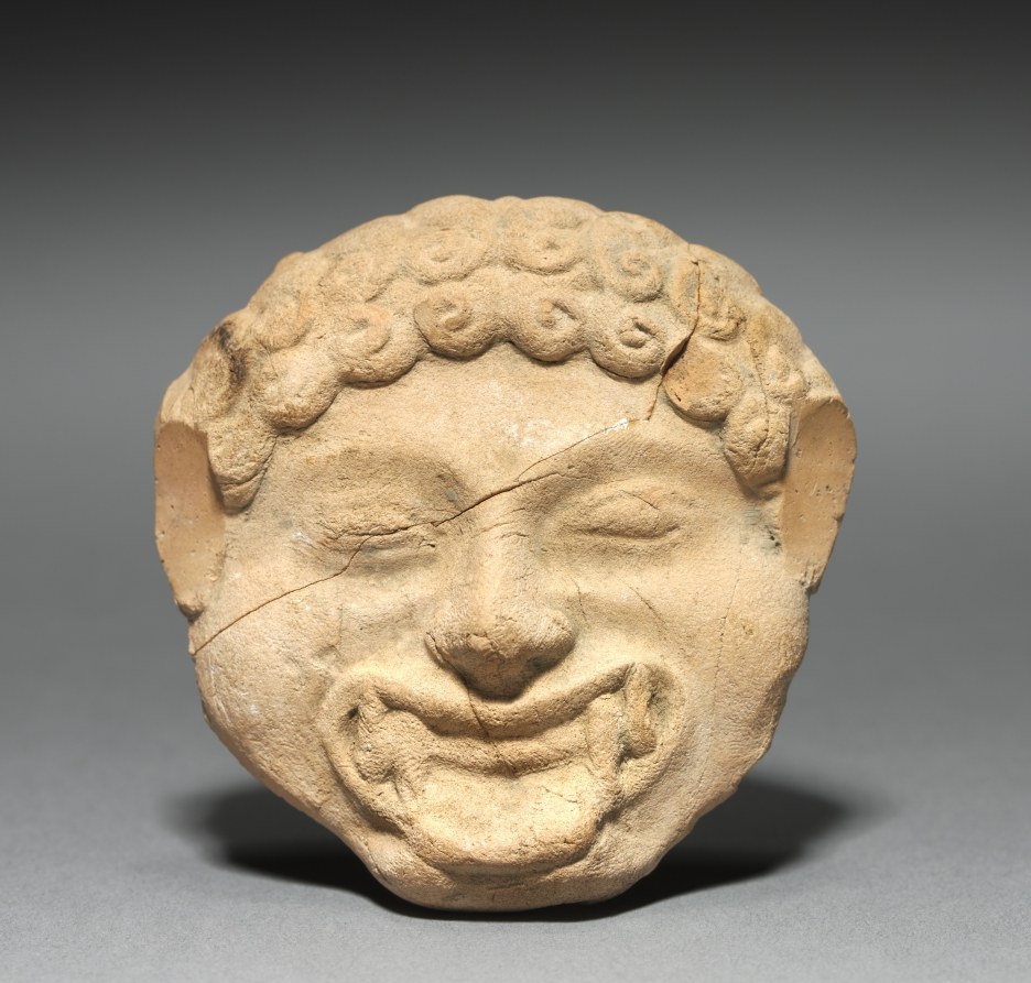 Terracotta plaque with molded Gorgon face on front, incised dancing satyr on back, ancient Greek, circa 525 BCE.